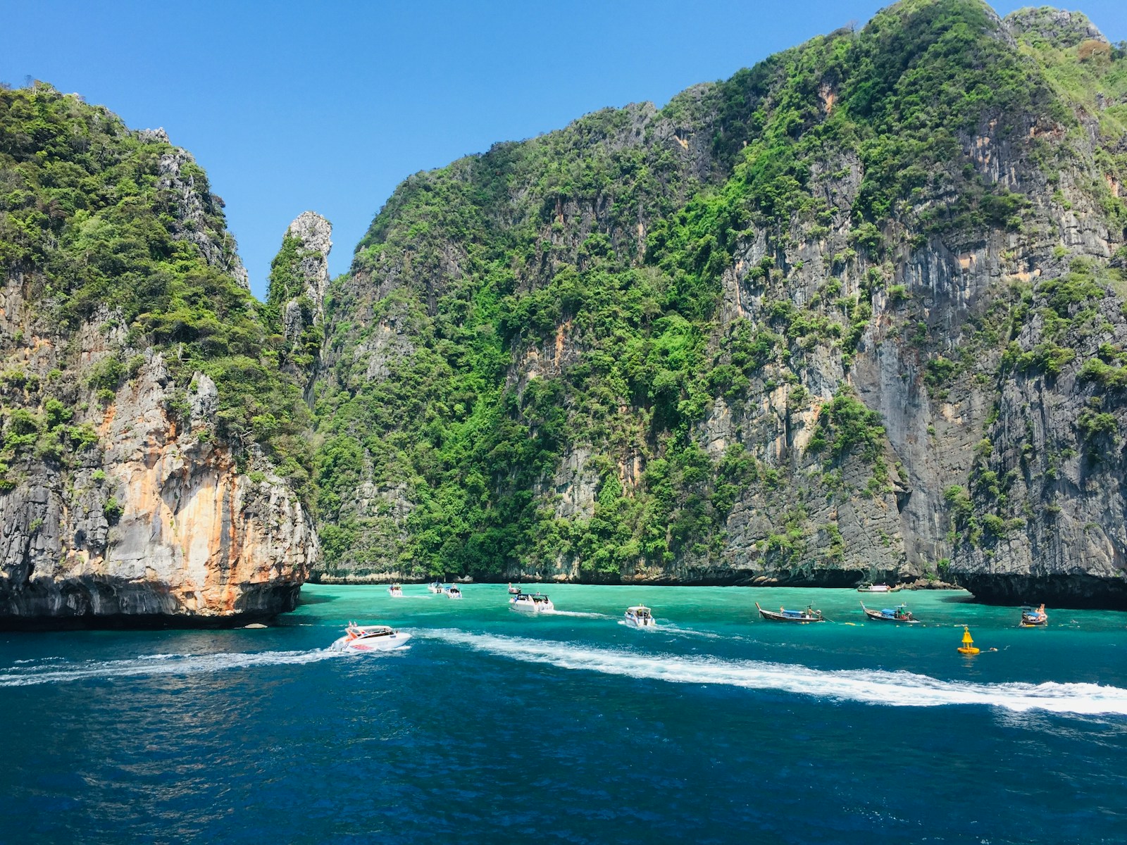 green and brown mountain beside body of water during daytime